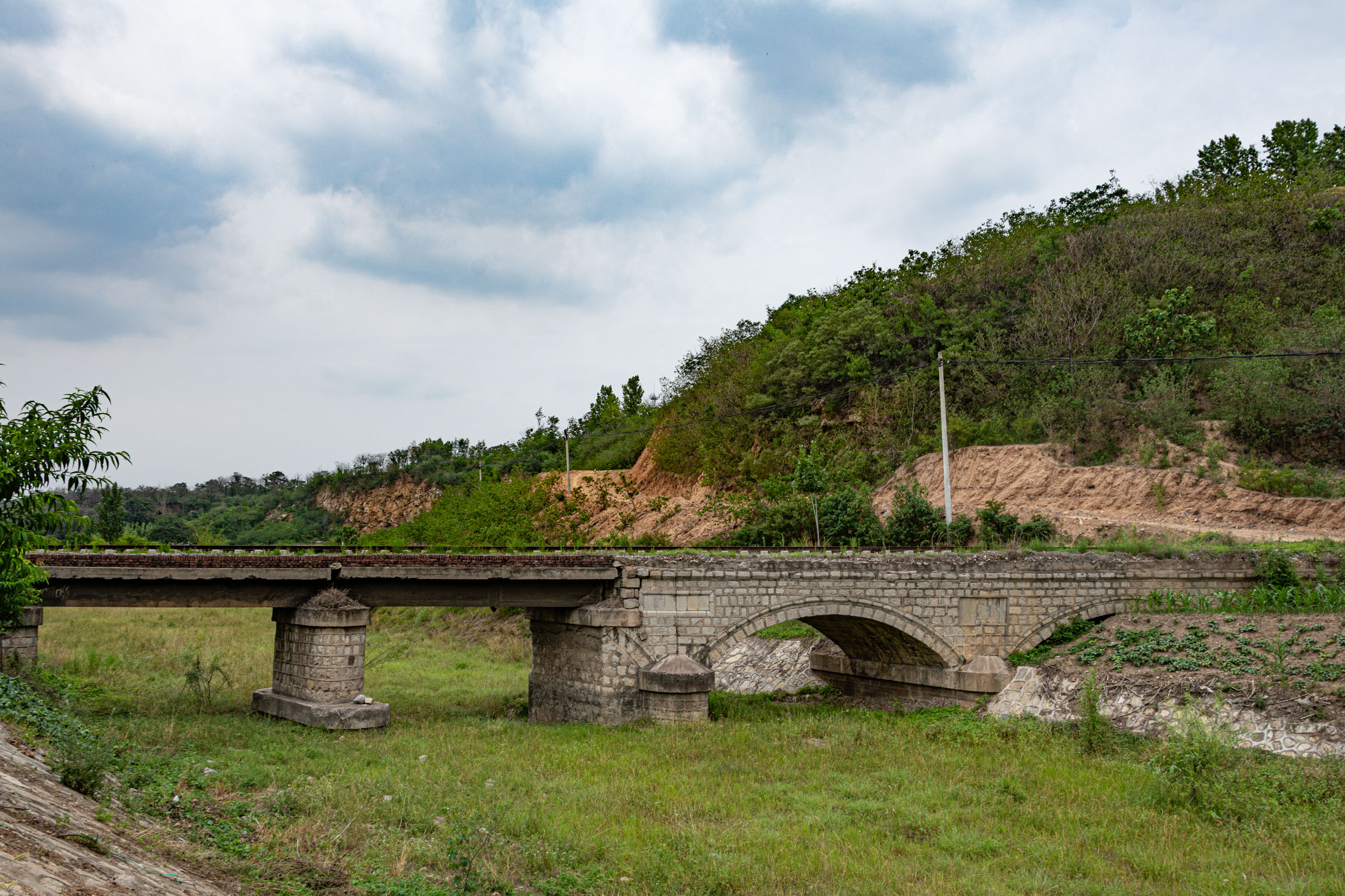 A hybrid bridge was formed by a beam bridge after a stone arch bridge was damaged by floods, 200 meters west near the old S323 road in Chaohua Town.